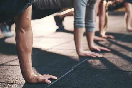 group of people in a gym doing pushups