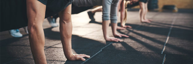group of people in a gym doing pushups