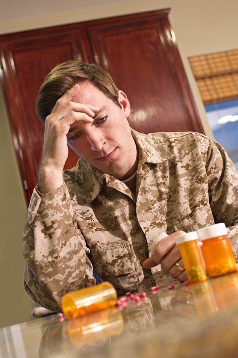 soldier looking at prescription drugs