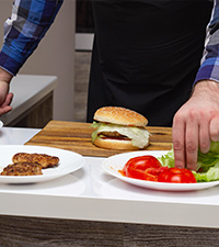 man cooking burgers for dinner