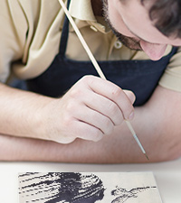 man concentrating on his painting