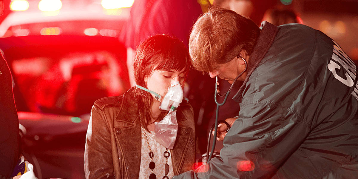first responder supporting a woman after a vehicle accident