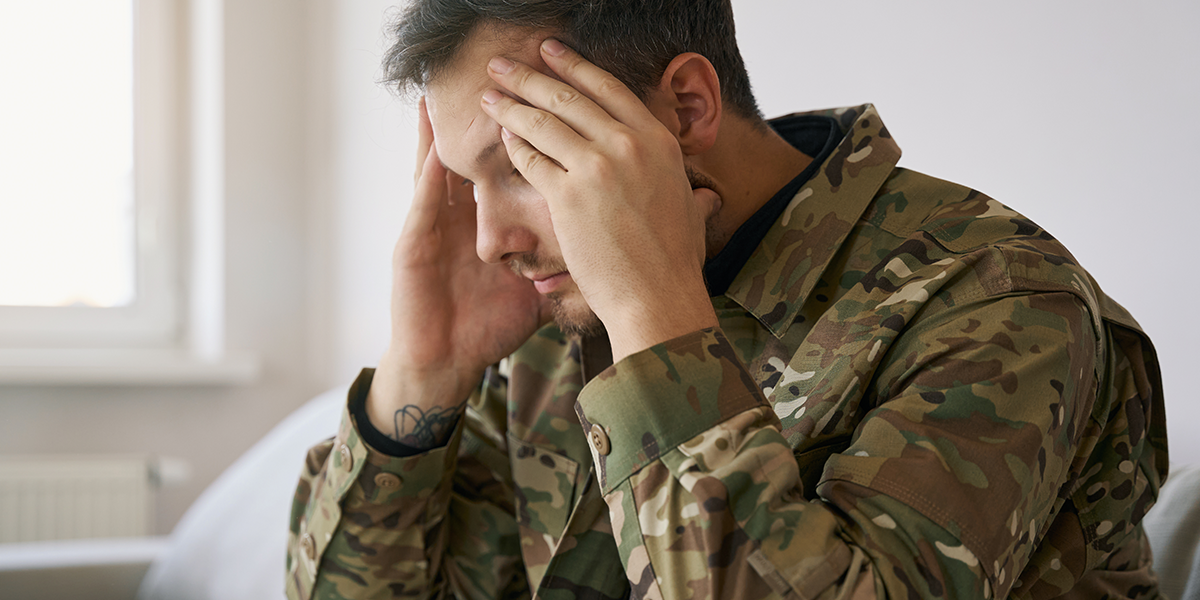 stressed warrior hands on head sitting on couch